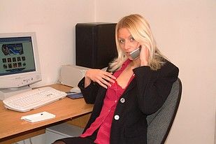 Slender blonde posing naked on her computer desk at work