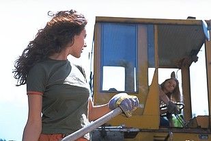 Two sexy babes play with each other on a construction site