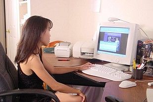 A sexy smoking Asian gets naked at her computer desk