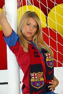 Busty fair haired sports fan posing on a soccer field